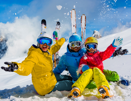 Skiing family enjoying winter vacation on snow in sunny cold day in mountains and fun. San Martino di Castrozza, Italy.