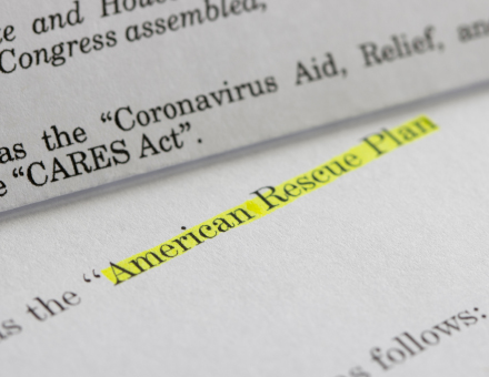 Closeup of the documents of both the Cares Act (Coronavirus Aid, Relief, and Economic Security Act) and the American Rescue Plan Act (ARPA) of 2021.