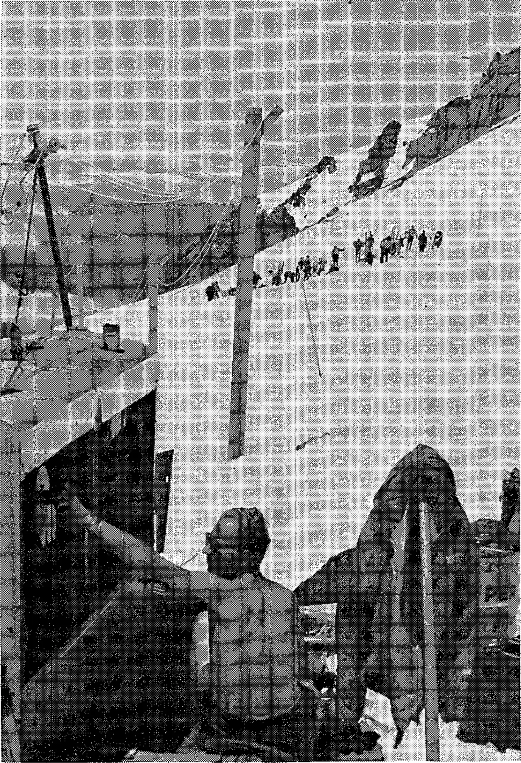 Engine-generator is located on firm ground. Power lines are strung on wooden poles 300 ft. over the snow.