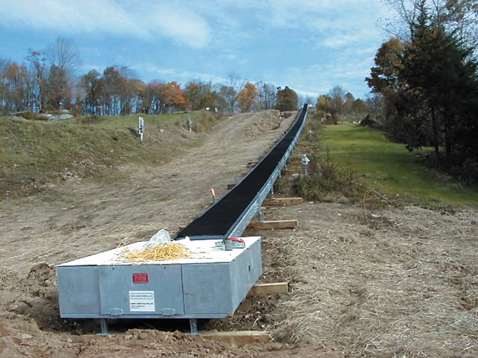Newly installed conveyor carpet on a grassy slope