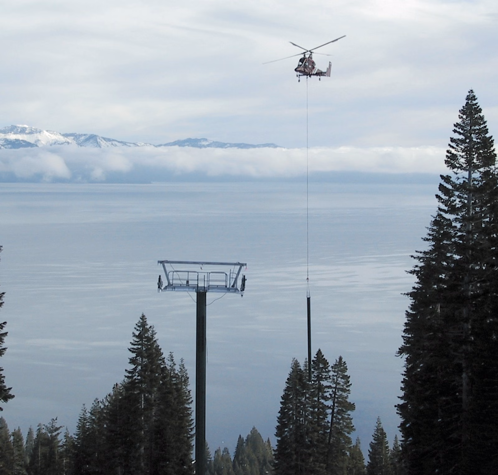 Helicopter flying a lift tower above Lake Tahoe at Homewood