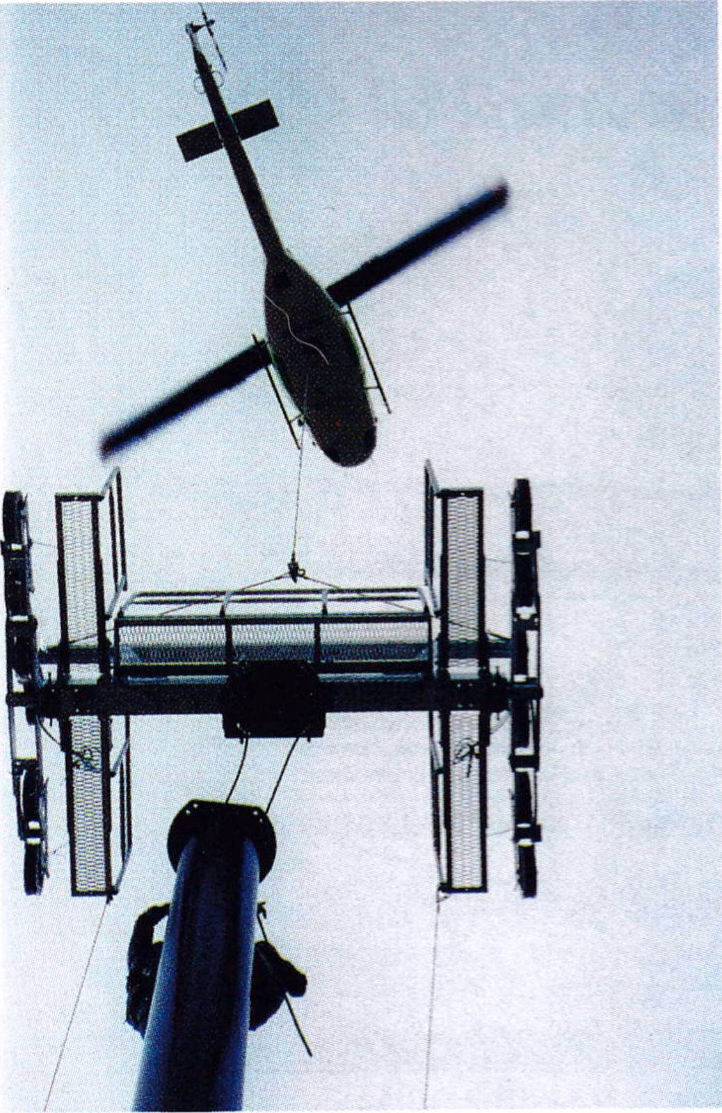 Helicopter lowering a lift tower section into place at Alta