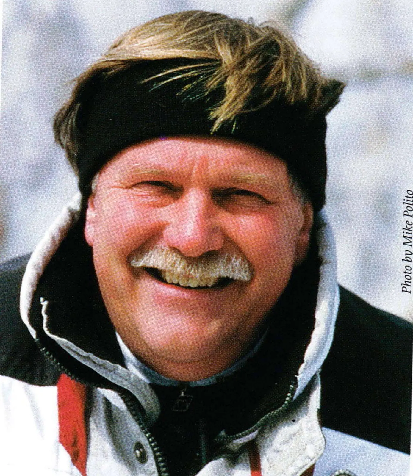 Portrait of Brian Fairbank, smiling, in a black headband and ski jacket