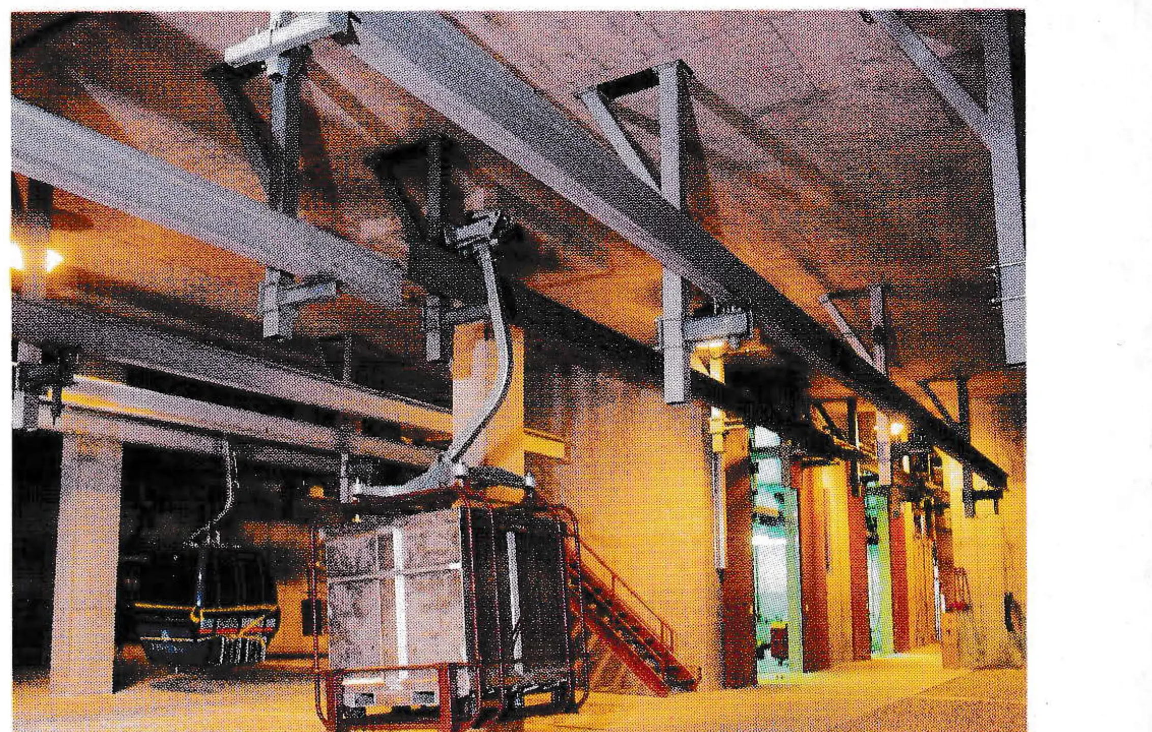 The connecting point between the two gondola lines for the materials handling system. Doors in background lead into maintenance bays. Cargo containers were designed specifically for this project and are handled by hangers and grips of each system.