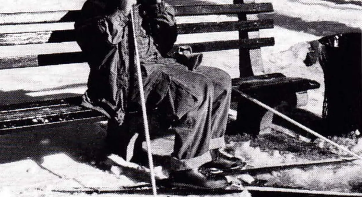 Skier in winter gear taking a break on a Central Park bench