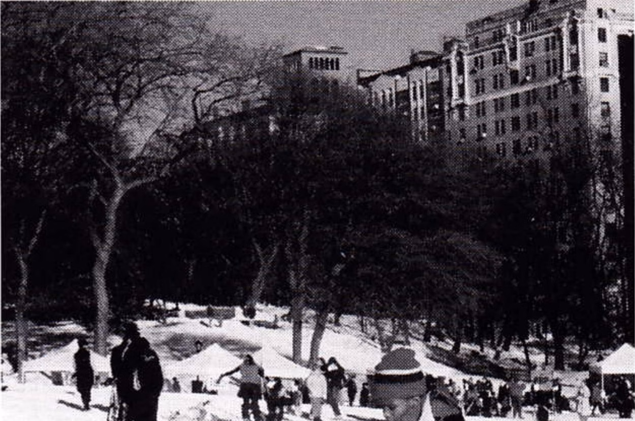 Snowshoer crossing the snow-covered East Meadow in Central Park with city buildings behind