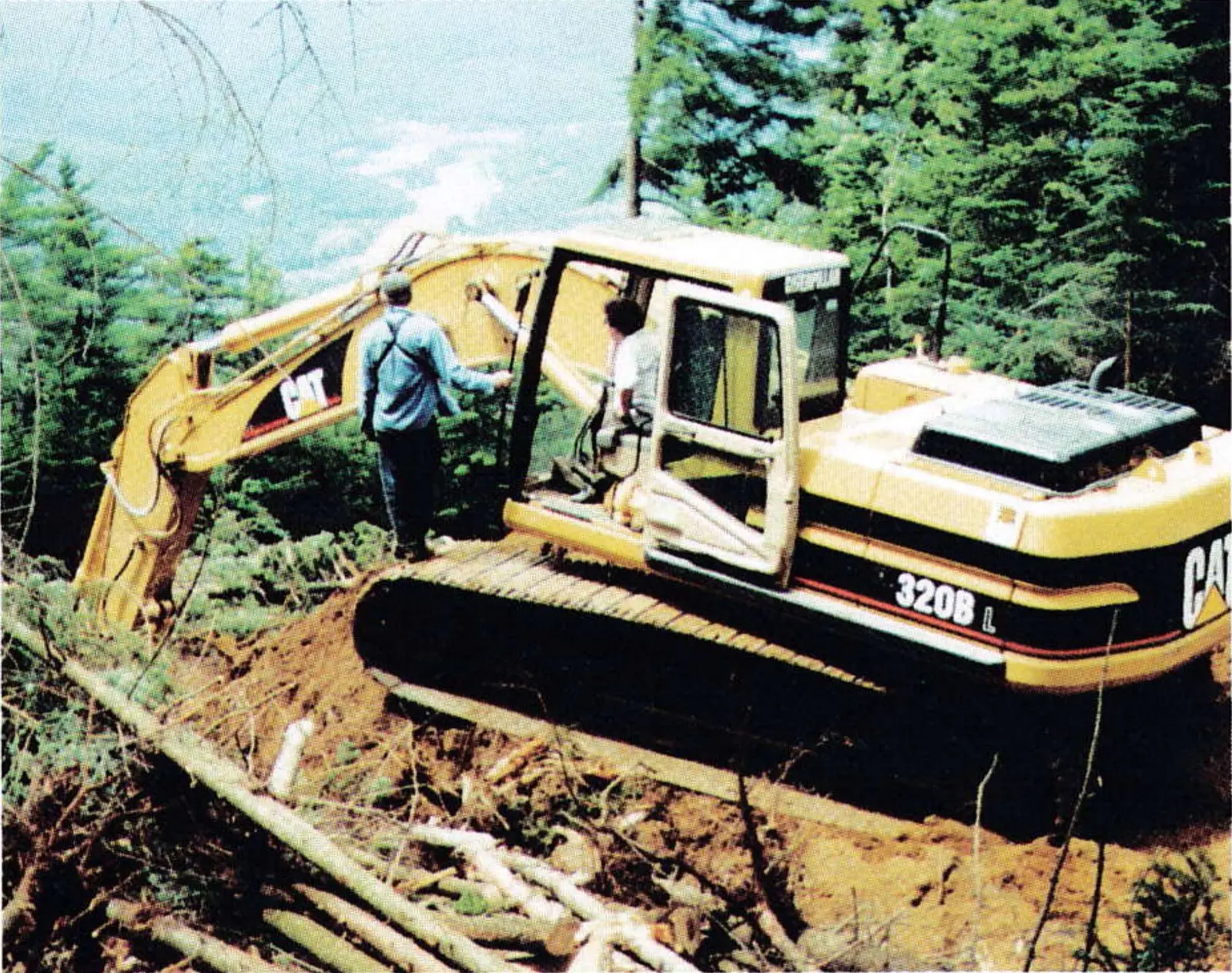 Excavator laying snowmaking pipe on a new trail at Ascutney Mountain Resort