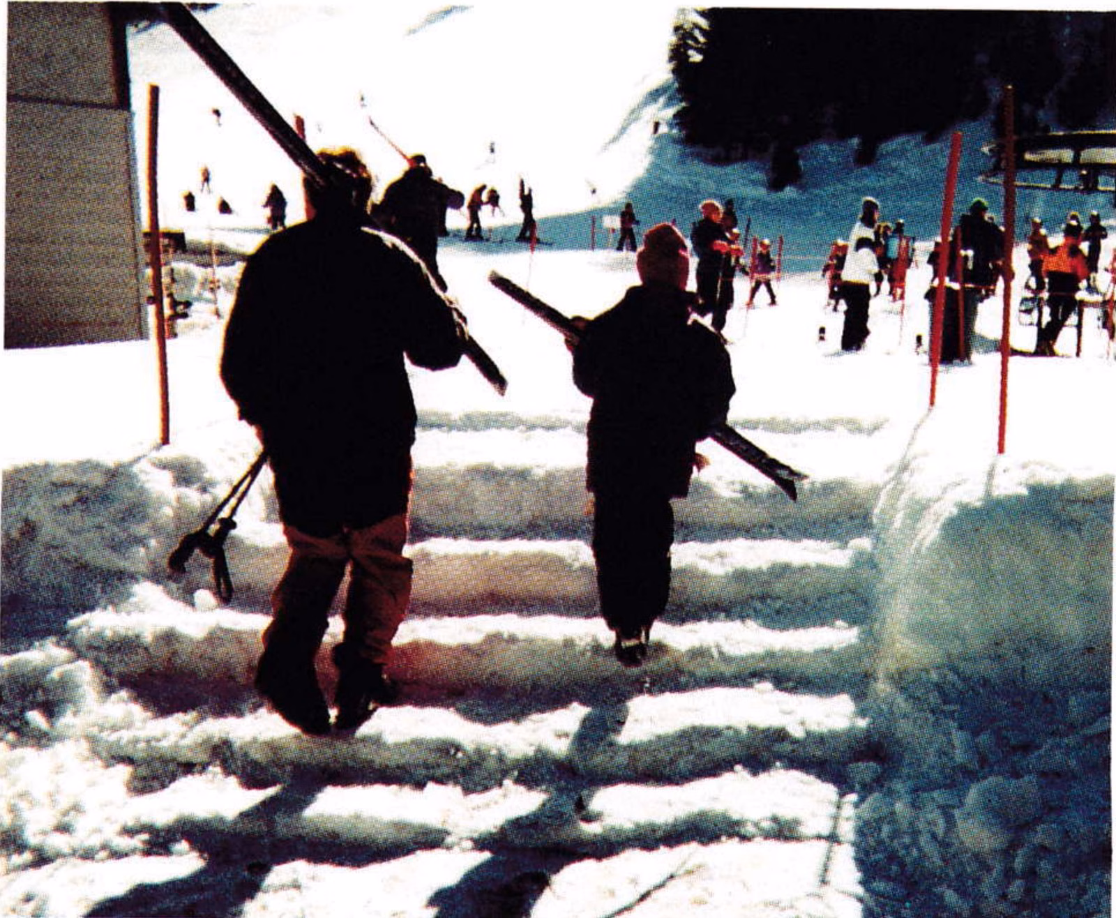 Skiers climbing snow steps from the parking lot at Diamond Peak