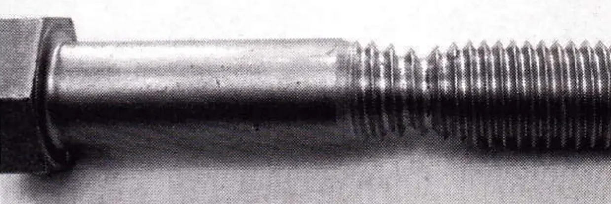 Close-up of a broken threaded bolt with a necked, stretched fracture end