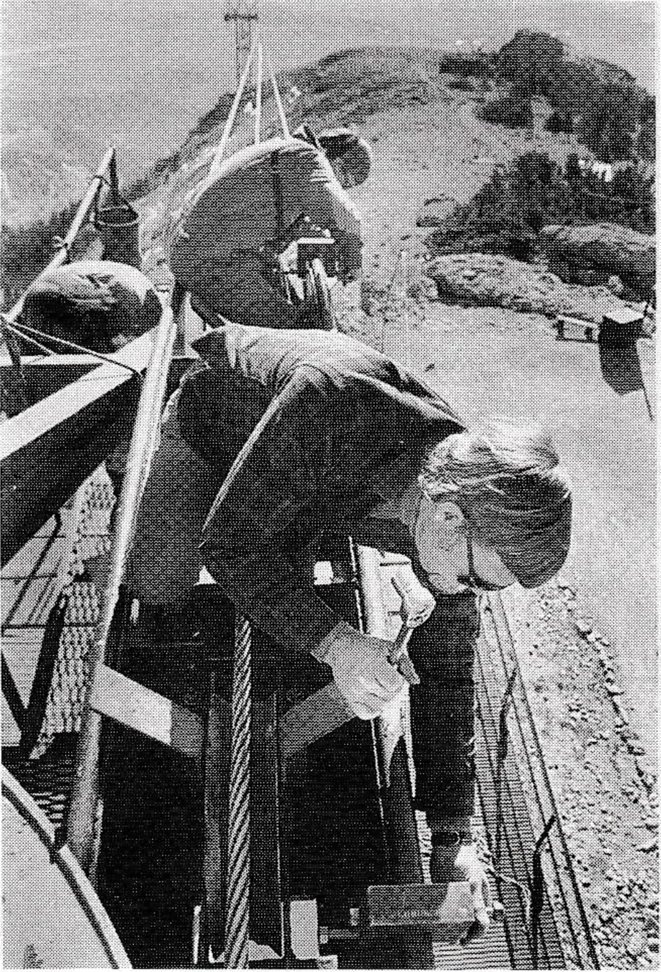 George Boyden, a “visiting fireman” from Sandia Peak, helps attach safety clamps around track to be let out 70 feet. Photo by Garth Dowling.