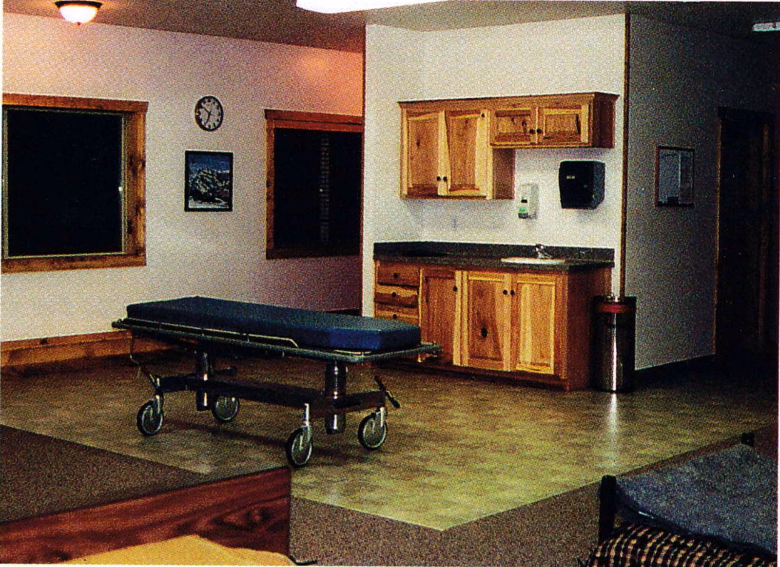 Interior of the patrol medical room with a gurney, wood cabinets and a kitchenette