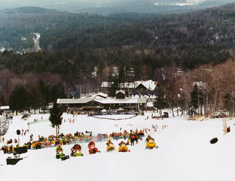 Snowmobile race on a ski slope below the base lodge