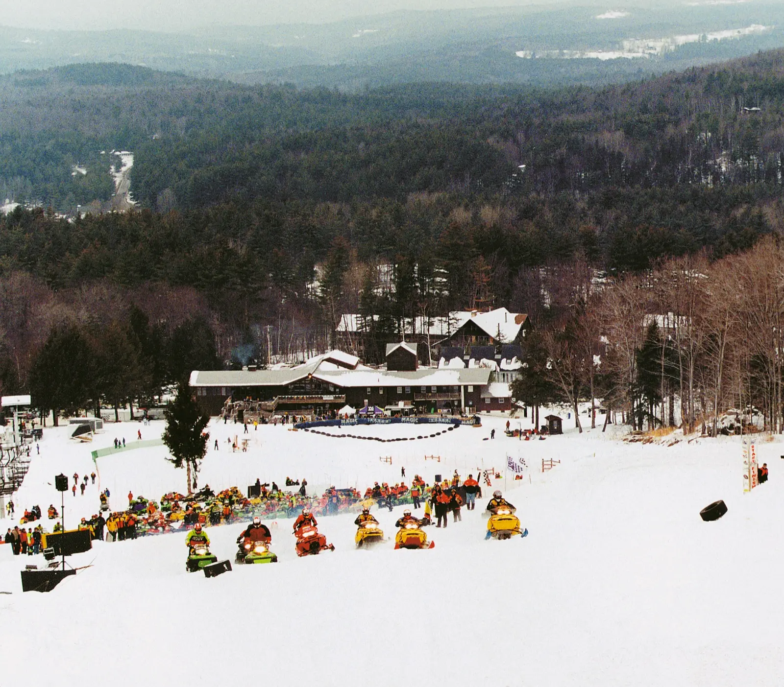 Snowmobile race on a ski slope below the base lodge