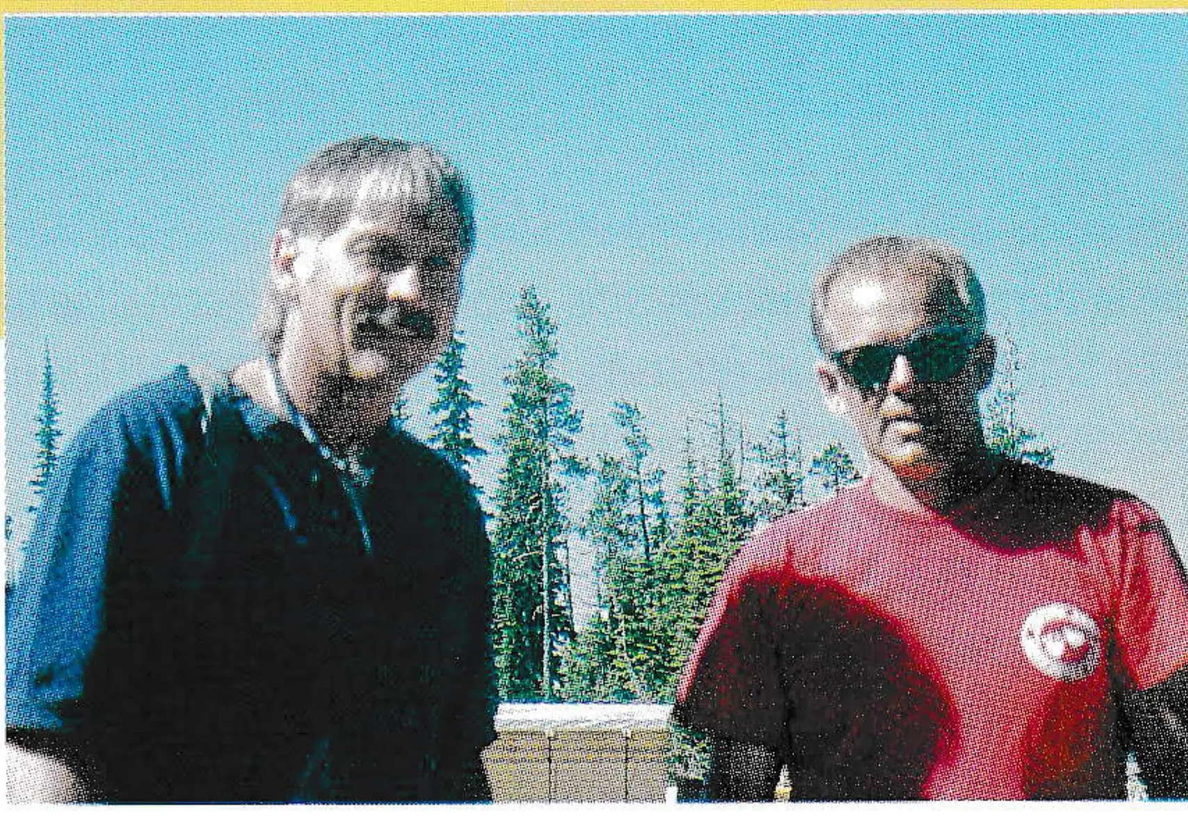 Steve Spencer and Dan Bovee standing outdoors with evergreen trees behind them