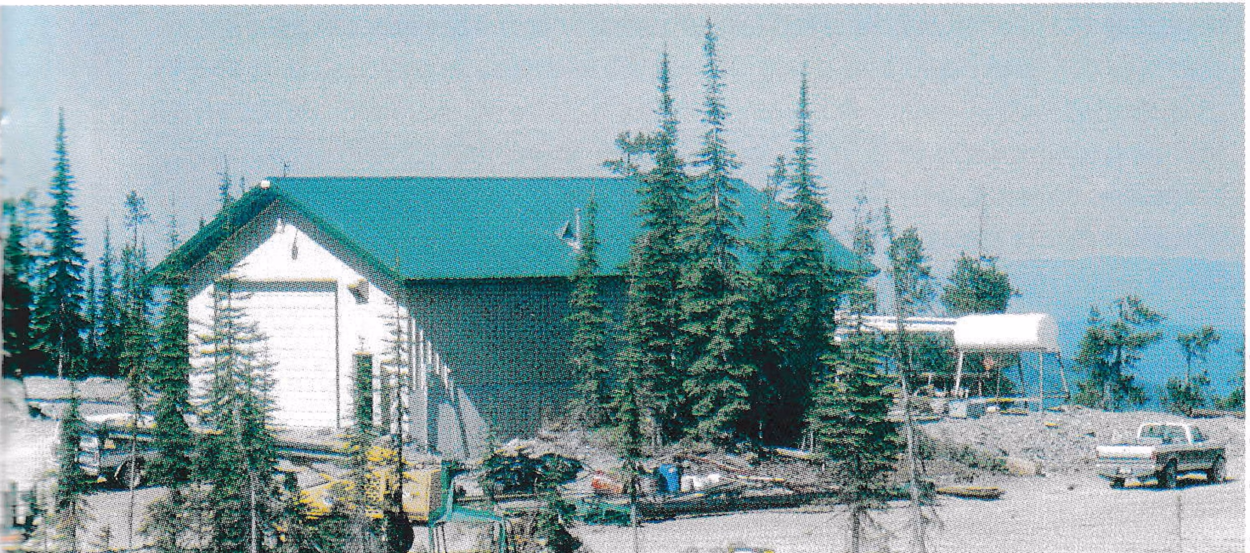 Green-roofed machine shop building among fir trees on Blacktail Mountain