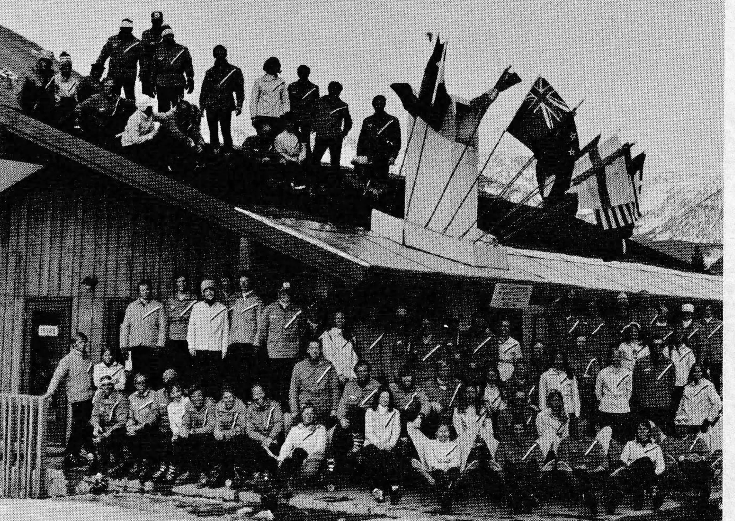 A group of instructors gathers around and atop the ski school at Vail. The flags, displayed every day, represent the nationalities of the staff.
