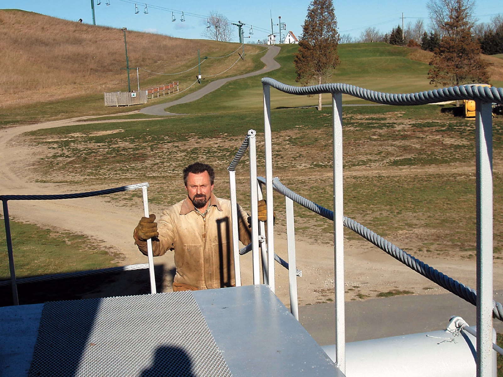 Man beside a railing made from old haul rope at a lift motor room