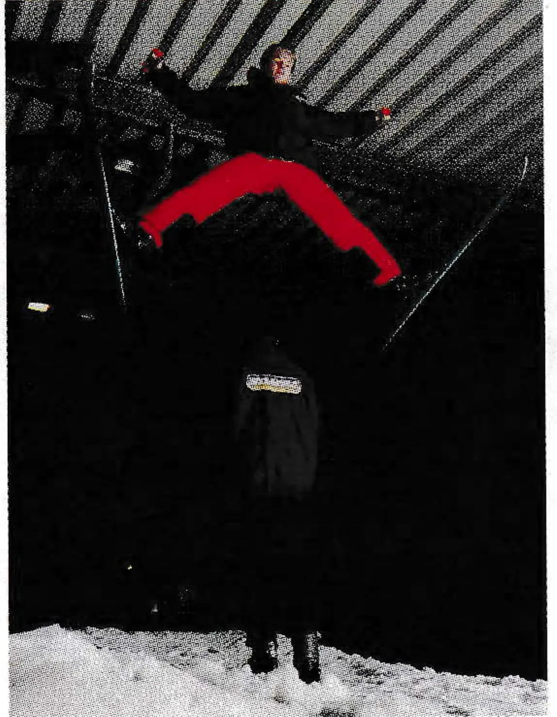 Skier in red pants jumping inside the dark SnowWorld dome