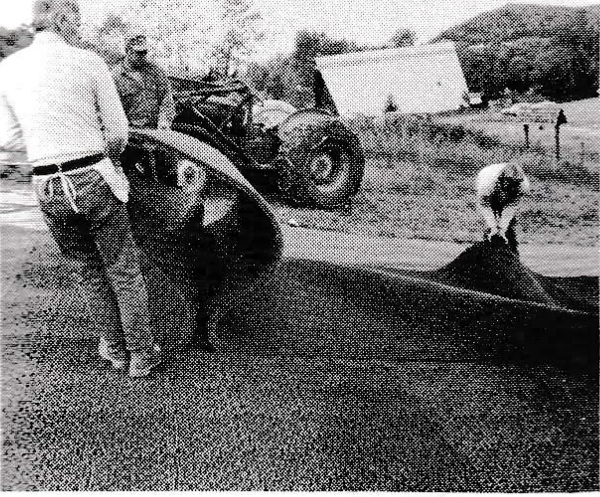 Plastic surface is maneuvered into place. The surface is 1.75 inches high and each square foot contains 2,500 plastic fingers.