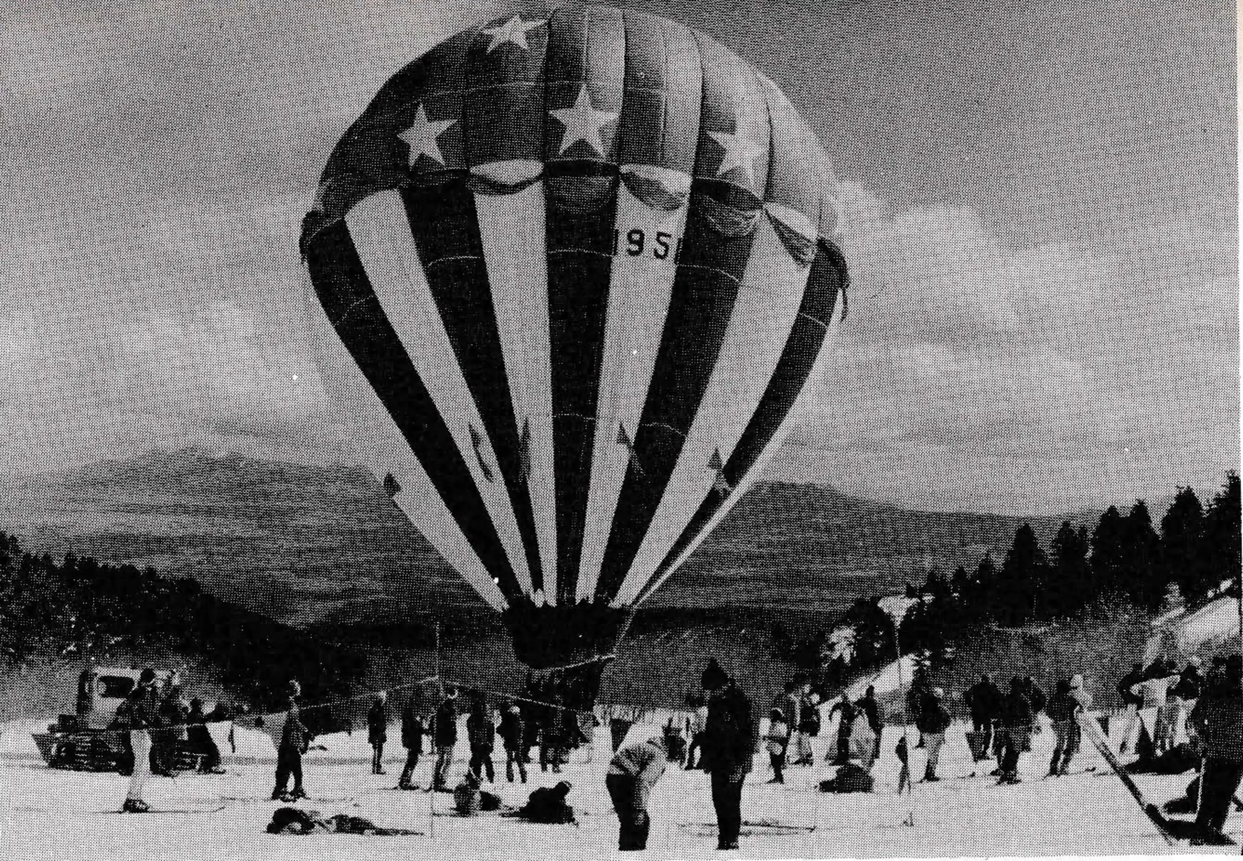 Skiers watch red-white-blue balloon preparing for flight