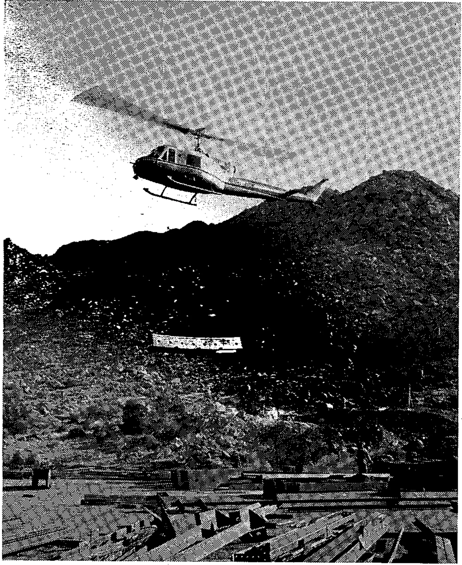 Jagged escarpment terrain over which Sandia Peak tram passes was a major factor in New Mexico resort's decision to employ this type of lift. In distant background is Albuquerque suburb. Sandia is using helicopters as transportation workhorses in tower construction phase.<br>Dick Kent” class=”wp-image-36733″/><figcaption class=