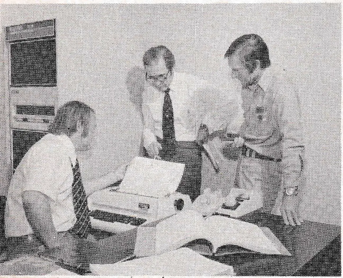 Dave Fleming (center) eyeballs some of the print-outs from the computer.