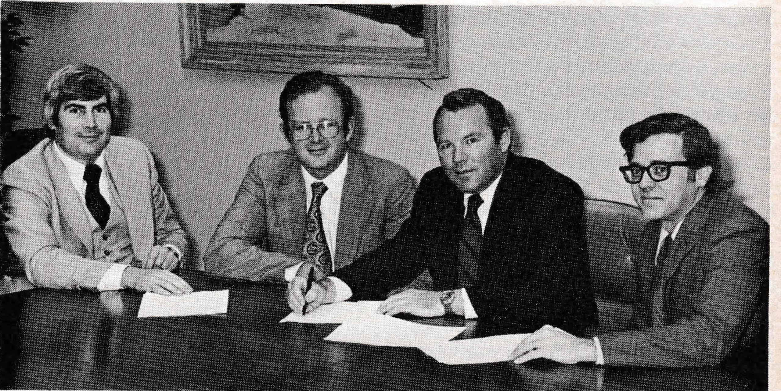 The four parties above are signing papers involving a $3,750,000 financing package — at least that is what the release says. Two of them are Michael Welch and Peter Hamblitt from the Manchester Bank, which led a group of seven New England banks in structuring the package. The other two — Tom Corcoran and Douglas Young — are from Waterville Valley. The contest is to try and guess who got the money, and who loaned it? (Correct answer on Page 27.) Included in the financing plan is nearly $1 million for new facilities consisting of a major snowmaking expansion, a new triple chairlift and base lodge expansion.