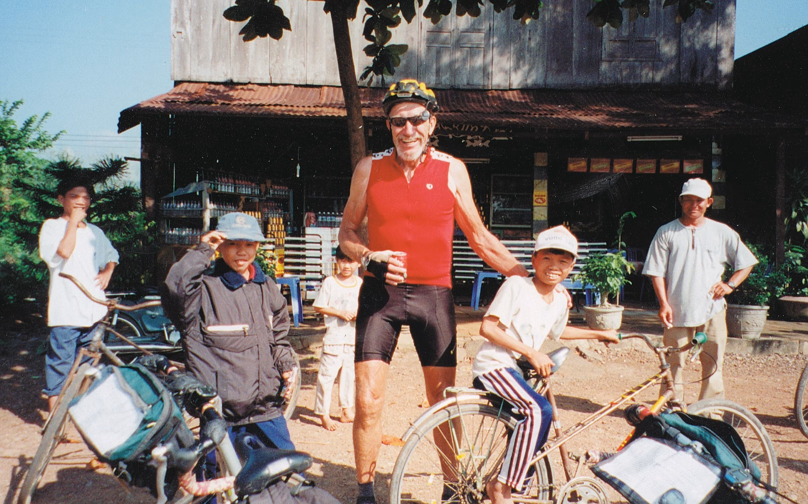 Cyclists with villagers outside a shop in Vietnam