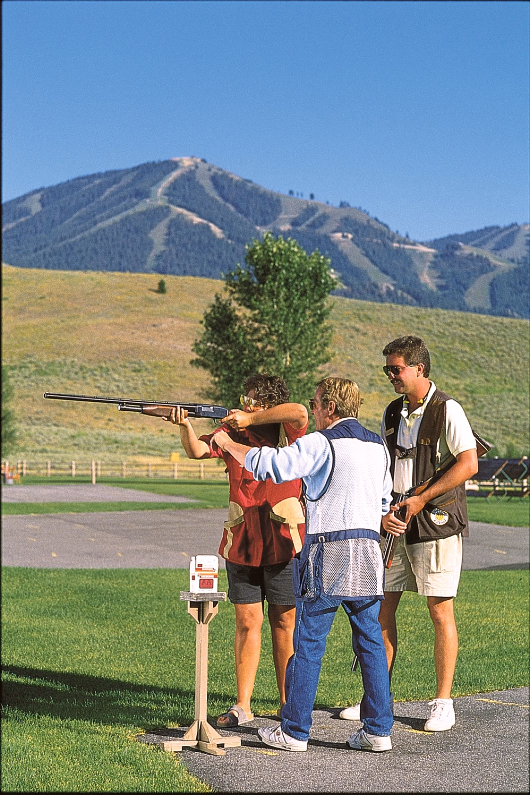 Guests trapshooting on a summer lawn below Bald Mountain